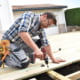 Carpenter with eyeglasses on building wooden deck