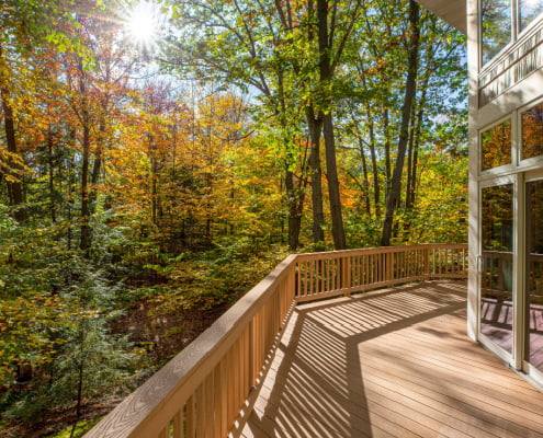 View from the deck of a luxury home in the autumn woods and intentional sun flare highlight