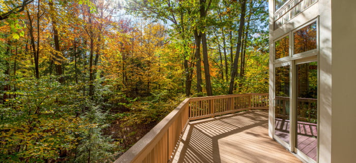 View from the deck of a luxury home in the autumn woods and intentional sun flare highlight